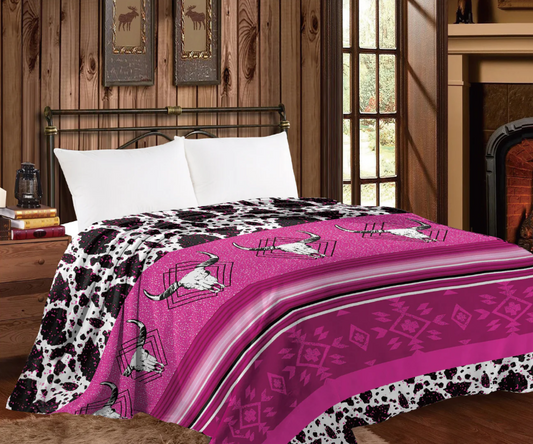 Mia Throw Blanket with pink longhorn skulls and cow print design on a bed.