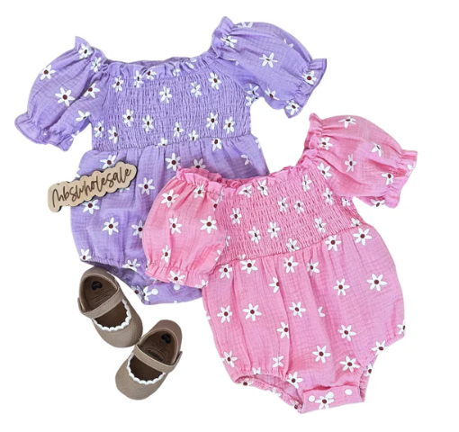 Bright floral linen romper in pink with strawberry design for babies.