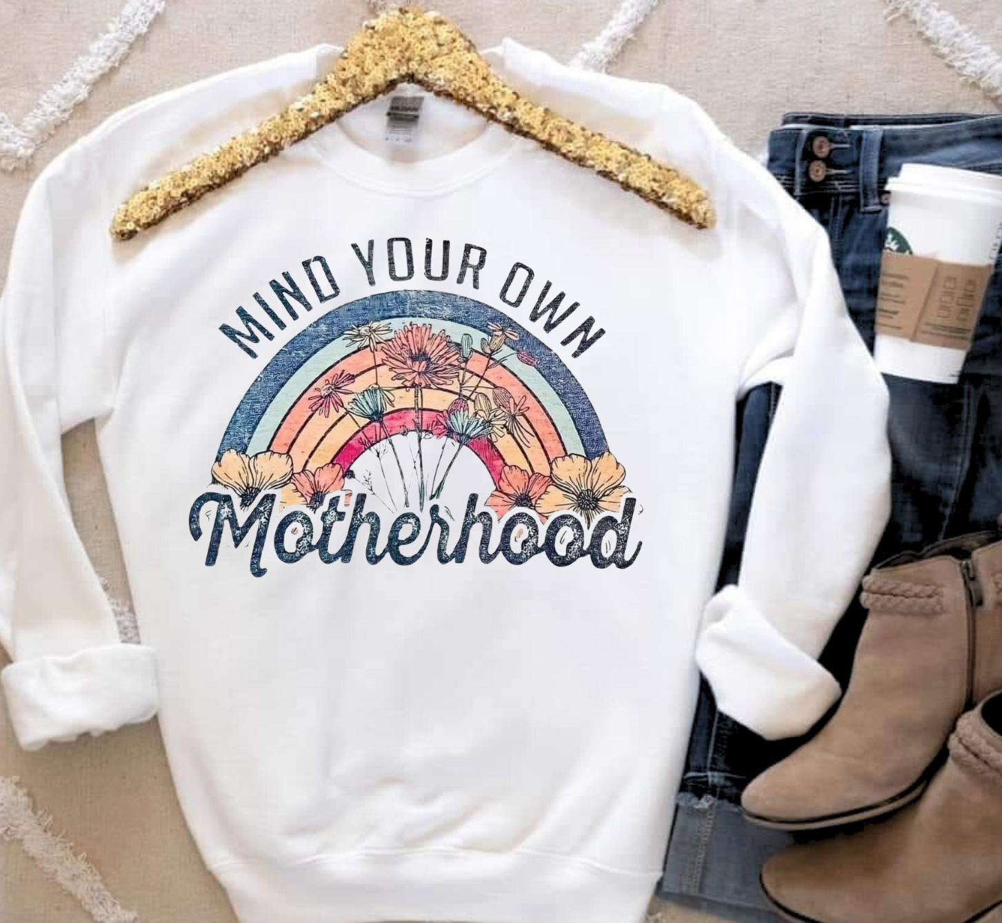 Mind Your Own Motherhood sweatshirt with retro rainbow and floral design.