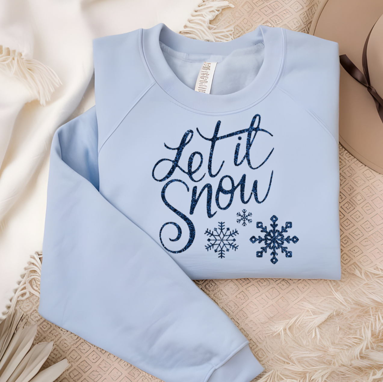Let It Snow shirt with whimsical snowflakes on a soft blue fabric.