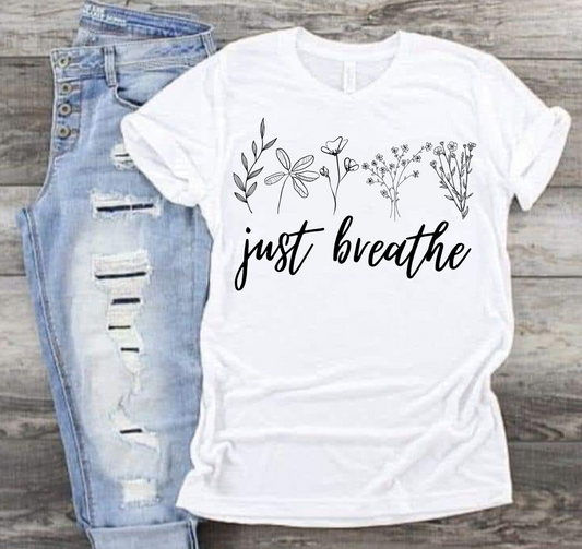 White "Just Breathe" T-shirt with floral design, casual and playful style.