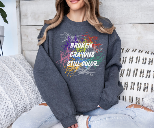 Broken Crayons sweatshirt featuring colorful design on dark fabric.
