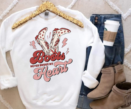 White Gildan sweatshirt with "Boots Never Broke My Heart" graphic, paired with jeans and tan boots.