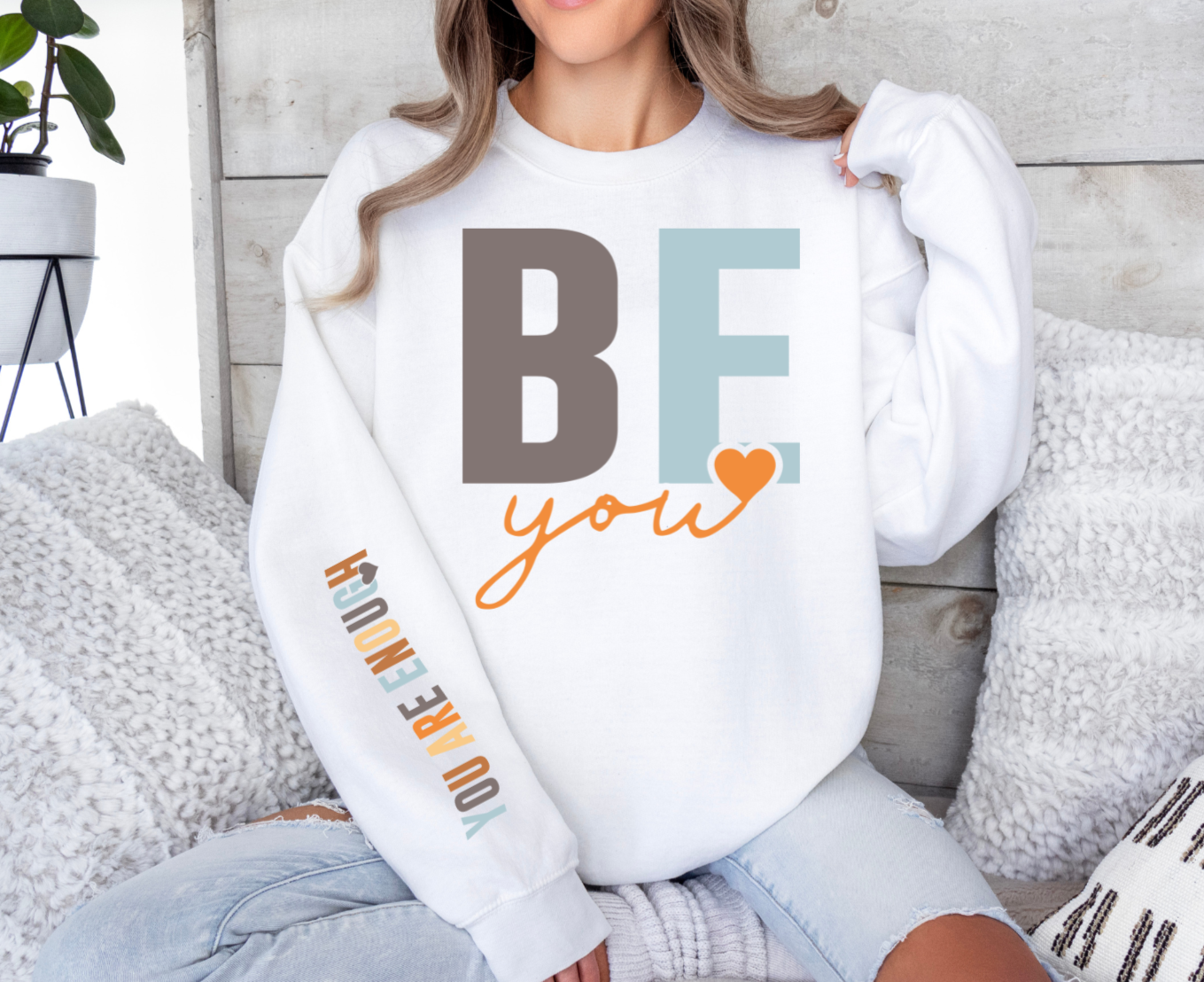 White sweatshirt with "Be You, You Are Enough" text and heart design.