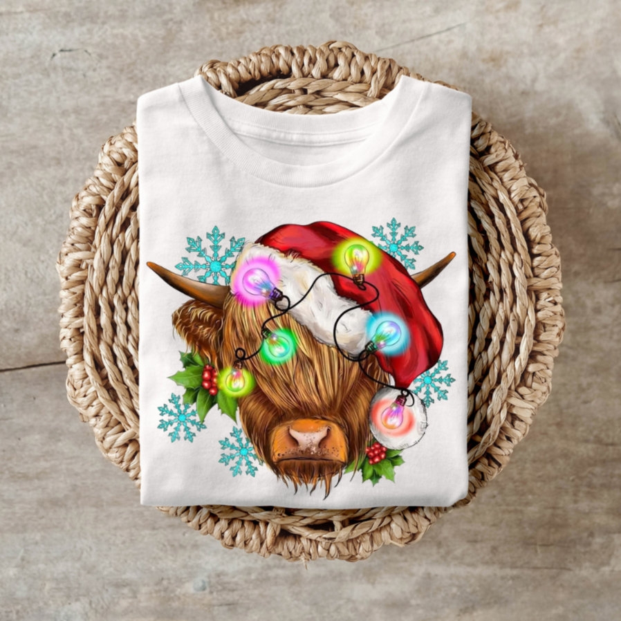 Highland cow with festive lights shirt for Christmas celebrations.
