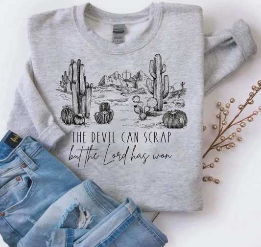 Gildan sweatshirt with "The Devil Can Scrap But the Lord Has Won" text and desert graphic.