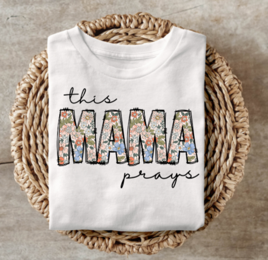 Mama Prays shirt with floral design on a wicker basket