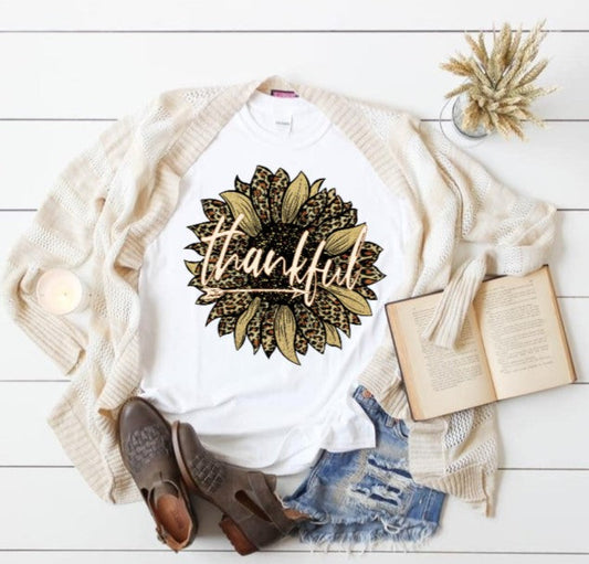 Thankful Sunflower Tshirt with fall design, styled with denim shorts, cardigan, and boots.
