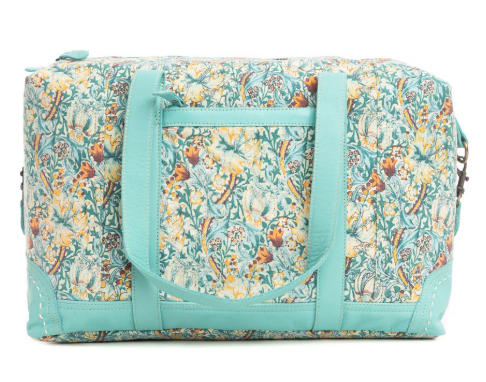 Serafina Duffle Bag with floral pattern and turquoise leather accents.