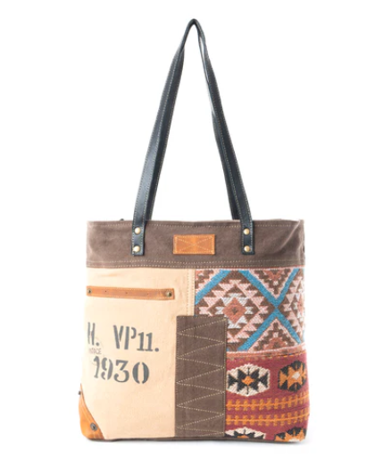 Southwest Bound Tote Bag with vintage overprint, woven rug patterns, leather straps, and zippered closure.