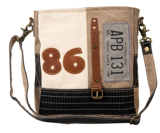 MYRA- Route 86 Shoulder Bag with vintage travel design, textured canvas, leather accents, and adjustable strap.