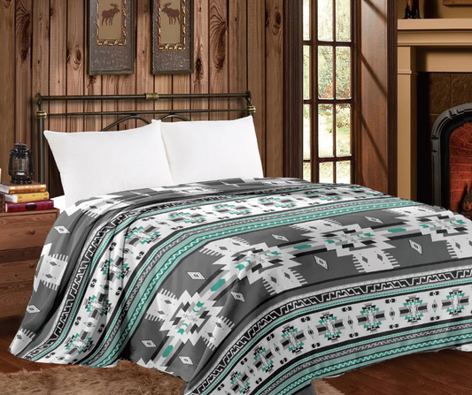Mia Throw Blanket in Grey Aztec design on a Queen-sized bed.