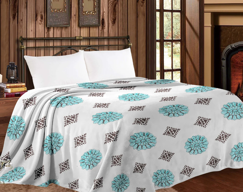 Mia Throw Blanket with western conchos design on bed in cozy room setting.