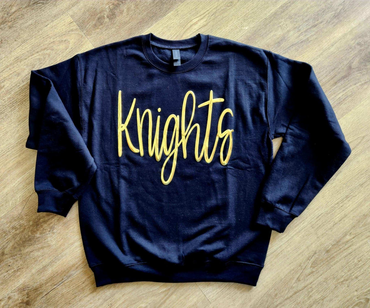 Black oversized Knights Jumbo Puff Sweatshirt with metallic gold "Knights" print on front.