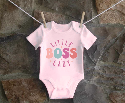 Infant bodysuit with "Little Boss Lady" text hanging on a clothesline.