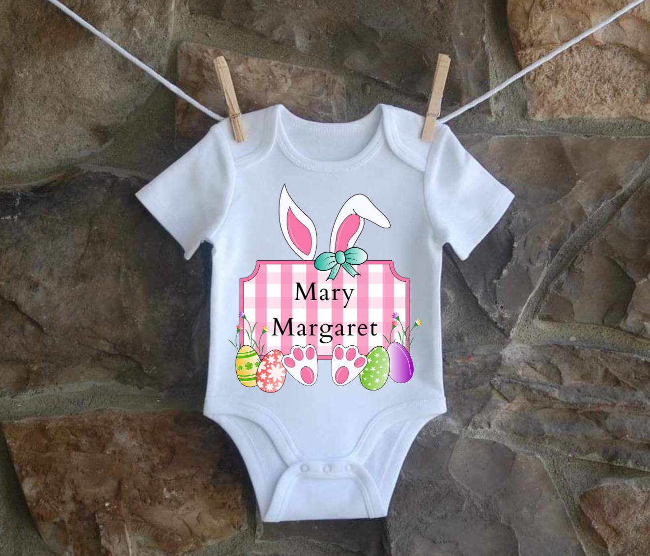 Personalized infant Easter Bunny shirt in pink hanging on line.