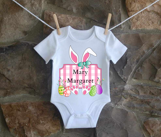 Personalized infant Easter Bunny shirt in pink hanging on line.