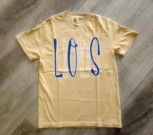 Yellow Lions Bubble Mascot T-shirt with blue and white playful lettering on wooden floor background