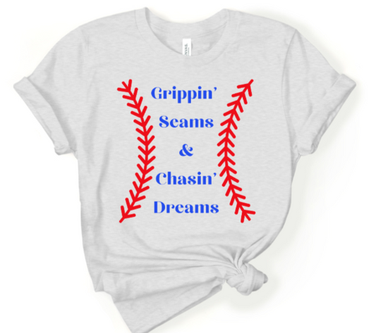 Softball and baseball themed Grippin Seams and Chasin Dreams T-shirt in gray with red and blue design.