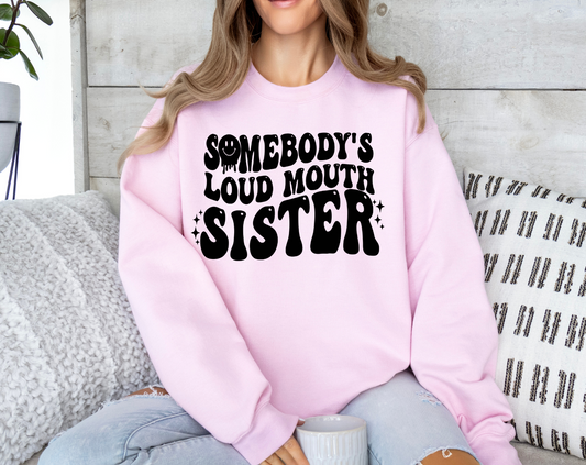 Woman wearing pink sweatshirt with "Somebody's Loud Mouth Sister" print.