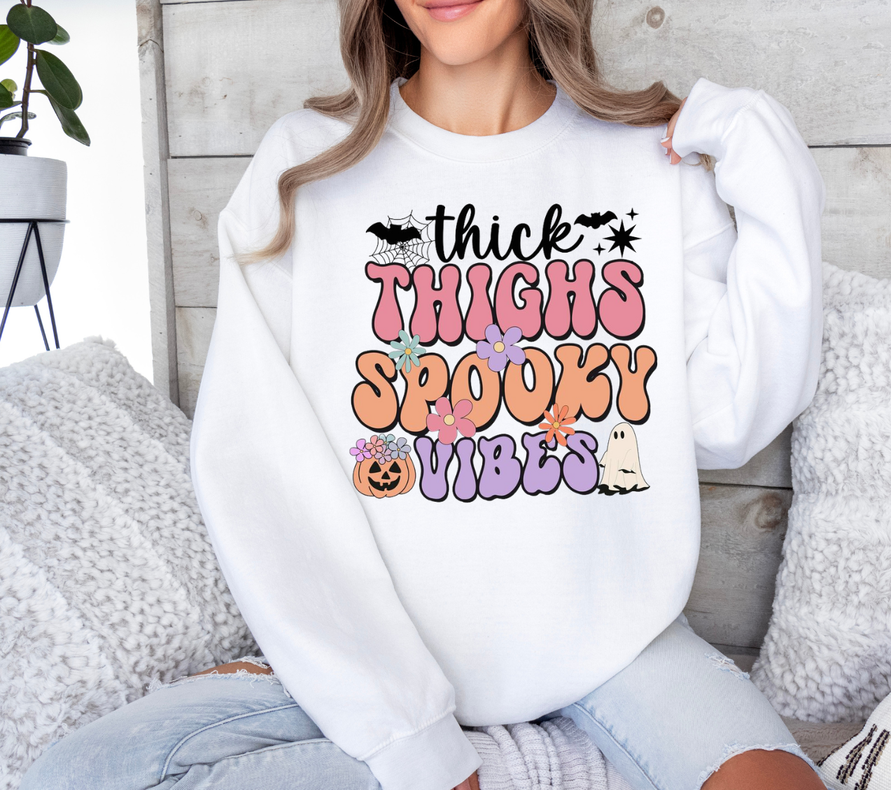 Thick Thighs Spooky Vibes shirt with colorful Halloween design worn by a woman.