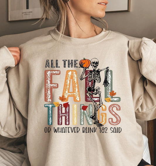 "All The Fall Things" shirt with skeleton holding a pumpkin for Halloween and autumn vibes.