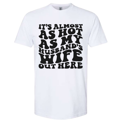 Quirky T-shirt with "It's Almost As Hot As My Husband's Wife Out Here" text.