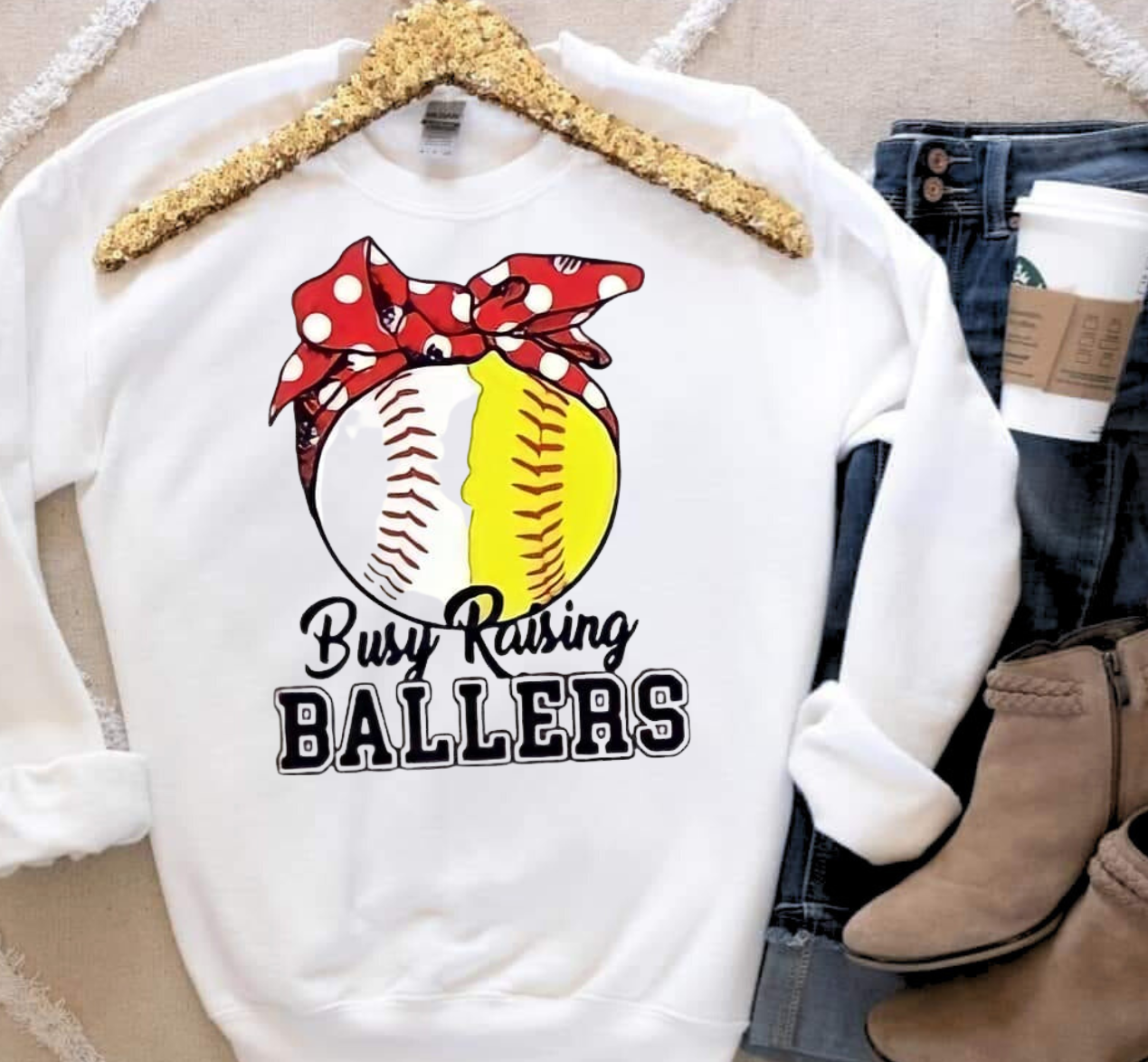 Busy Raising Ballers sweatshirt with baseball/softball design and red bow.