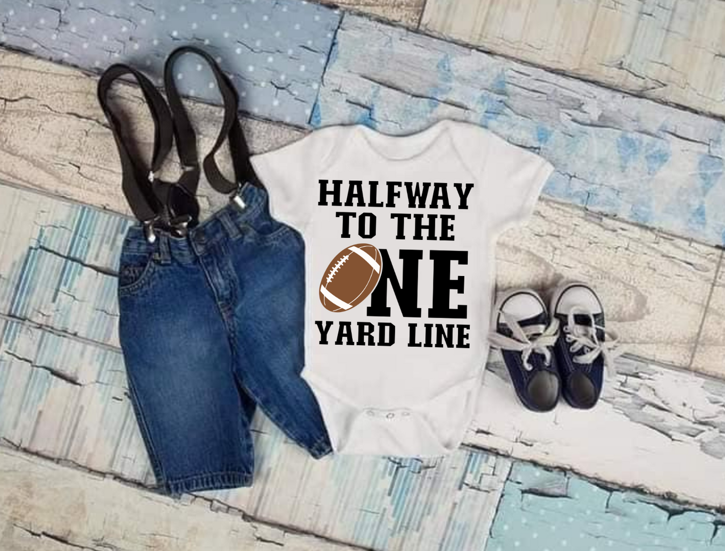 Halfway To The One Yard Line T-shirt with football graphic, paired with jeans and shoes.