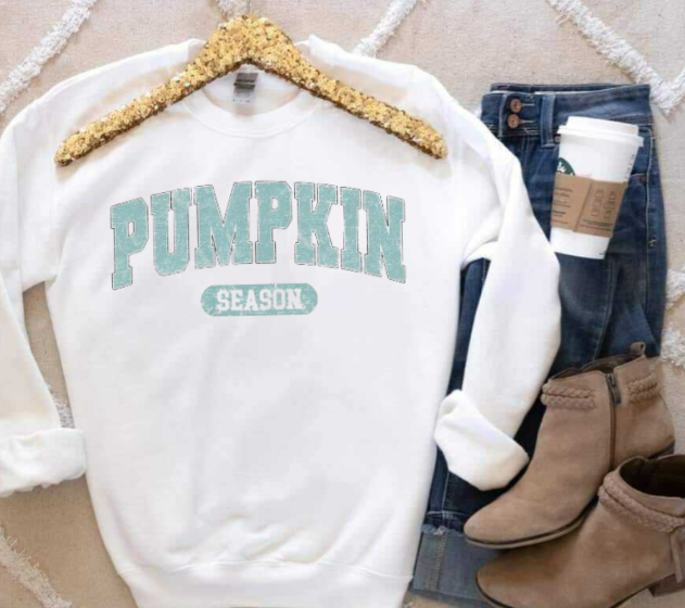Pumpkin Season shirt on hanger with jeans, boots, and coffee cup nearby.